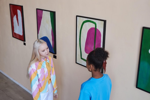 High angle view of two teenage girls talking visiting art gallery or museum