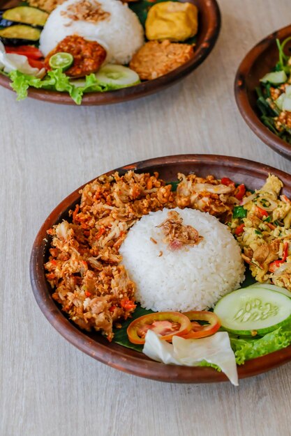 Photo high angle view of uduk rice chicken pecel in plate on table