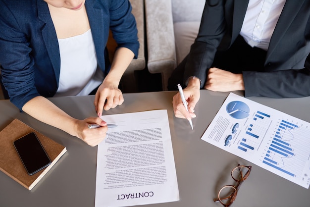 High angle view of unrecognizable business women signing a contract