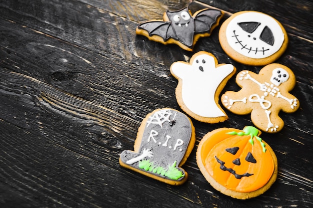 Photo high angle view of various cookies on wooden table during halloween