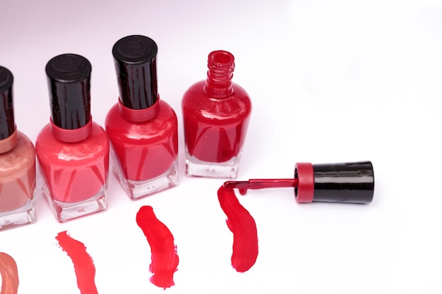 high angle view of various nail polish bottles with stains on white background