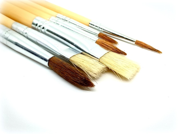 Photo high angle view of various paint brush against white background