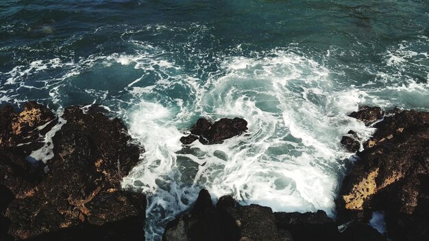 High angle view of wave splashing on rocks