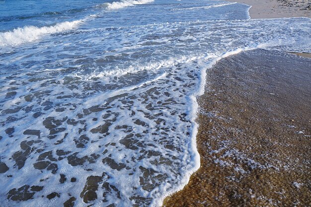 High angle view of waves rushing towards shore