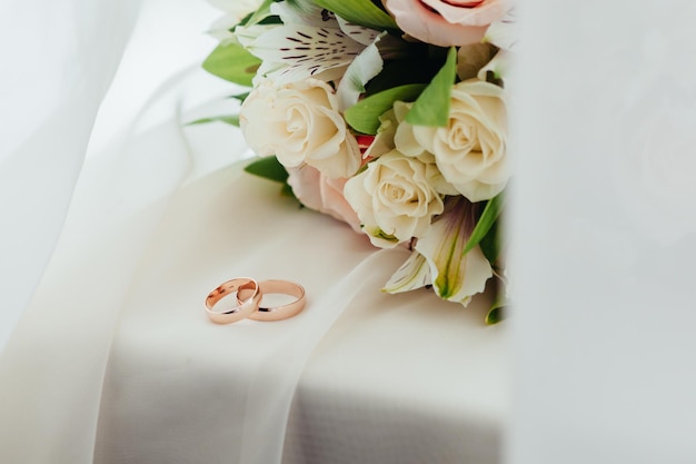 テーブルの上の結婚指輪と花束の高角度のビュー