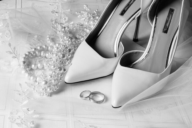 High angle view of wedding rings with shoes on table