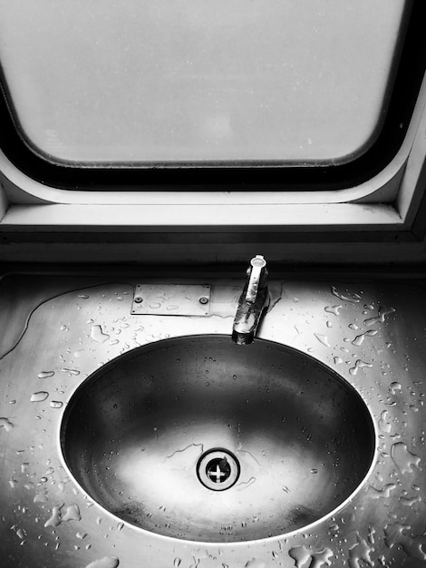 Photo high angle view of wet bathroom sink by window