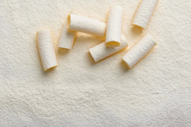 High angle view of whole grain Italian pasta sprinkled with flour on a flat surface with copy ad space