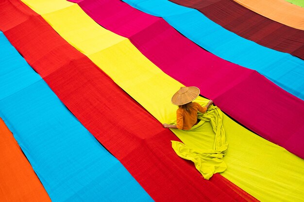 High angle view of woman arranging colorful textile