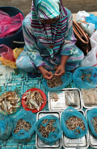 魚市場でエビを掃除している女性の高角度の写真