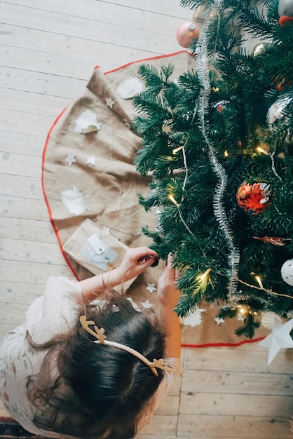 クリスマスツリーを飾っている女性の高角度の写真