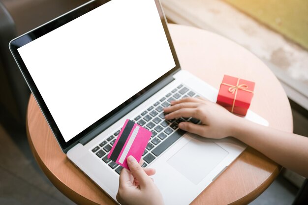 High angle view of woman doing online shopping on laptop at table in cafe