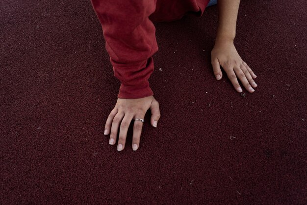 Foto vista ad alta angolazione delle mani della donna sulla pista sportiva