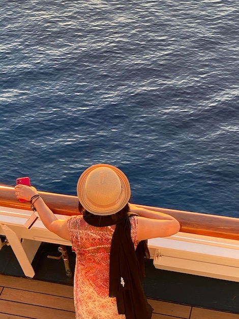 Foto vista ad alta angolazione di una donna con un cappello sul mare