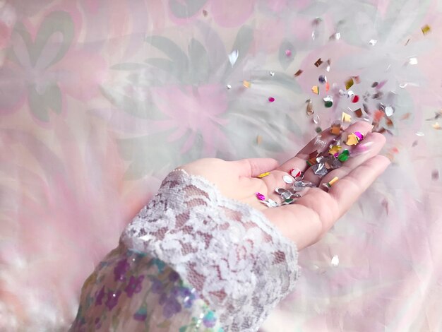 High angle view of woman holding multi colored confetti