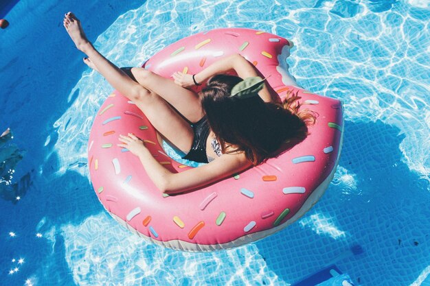 Foto vista ad alto angolo di una donna in un anello gonfiabile sulla piscina