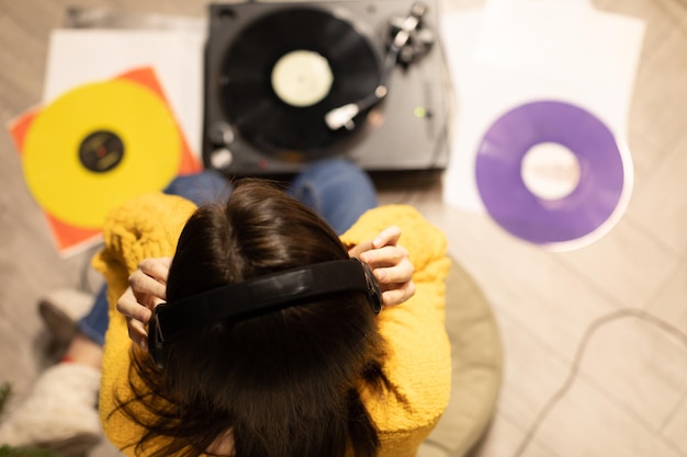 Foto vista ad alto angolo di una donna che ascolta musica a casa