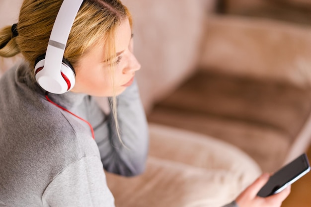 high angle view of woman listening music while sitting on sofa