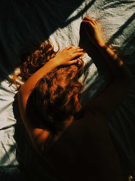 Photo high angle view of woman lying on bed