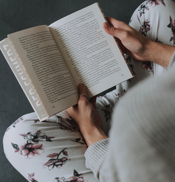 Высокоугольный вид женщины, читающей книгу