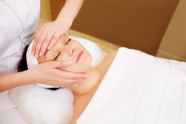 high angle view of woman receiving facial massage in spa