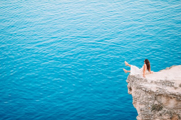 Foto vista ad alta angolazione di una donna su una roccia vicino al mare