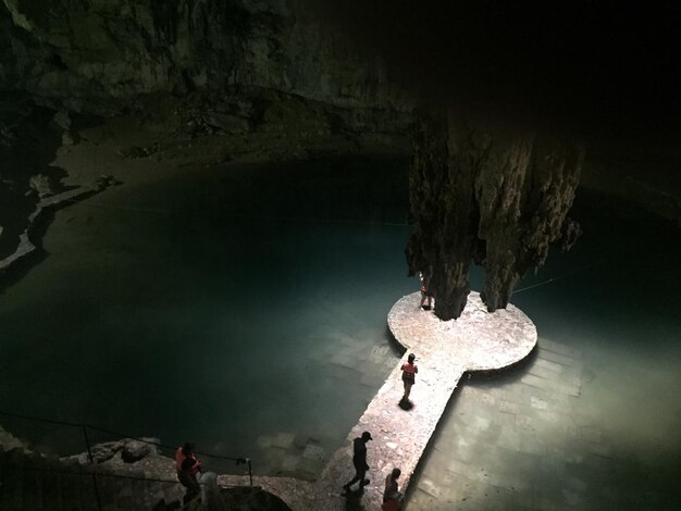 Foto vista ad alta angolazione di una donna su una formazione rocciosa in mare