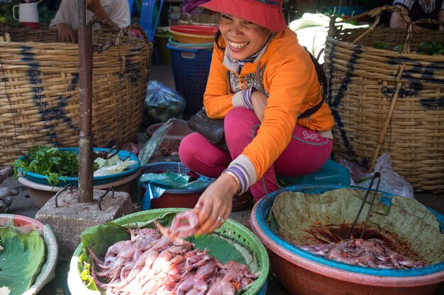 Photo high-angle view of a woman selling frogs at the wet market in phnom penh cambodia