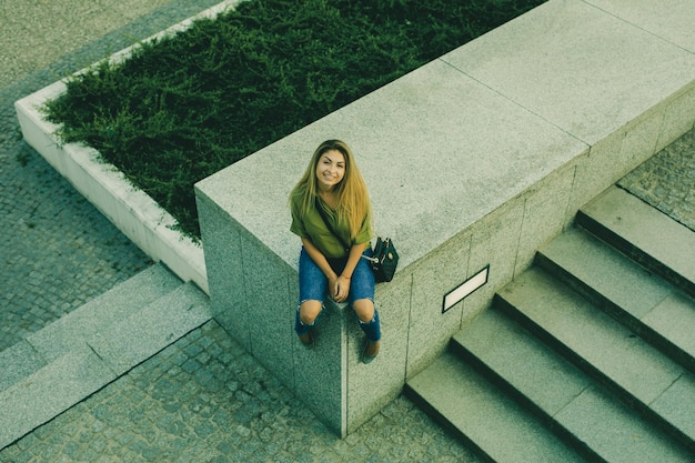 High angle view of woman sitting by staircase