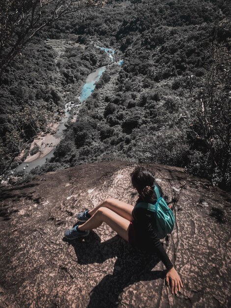 Foto vista ad alta angolazione di una donna seduta su una roccia