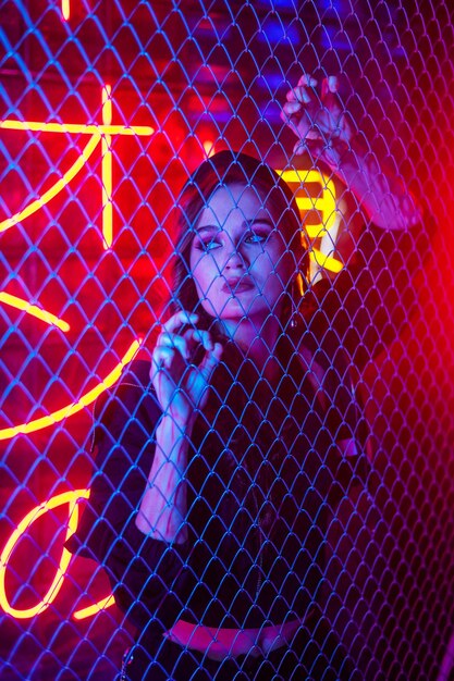 Photo high angle view of woman standing on chainlink fence