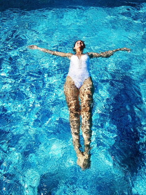 Foto vista ad alta angolazione di una donna che nuota in piscina