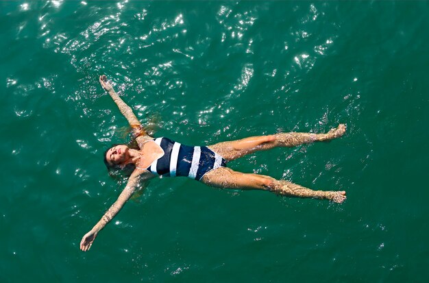 Foto vista ad alta angolazione di una donna che nuota in mare