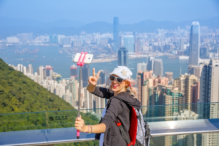 Photo high angle view of woman taking selfie with mobile phone against cityscape