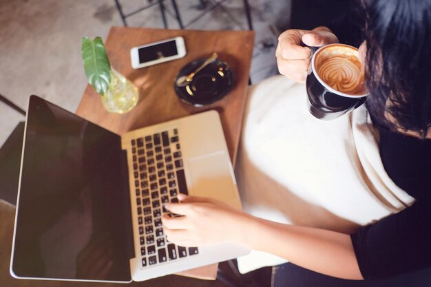 High angle view of woman using laptop in cafe