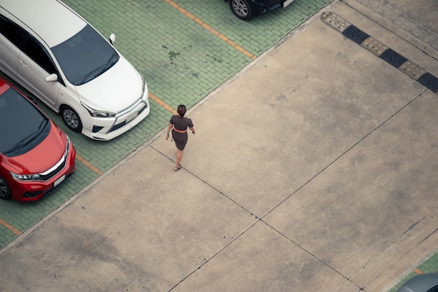 駐車場で歩いている高角度のビュー女性