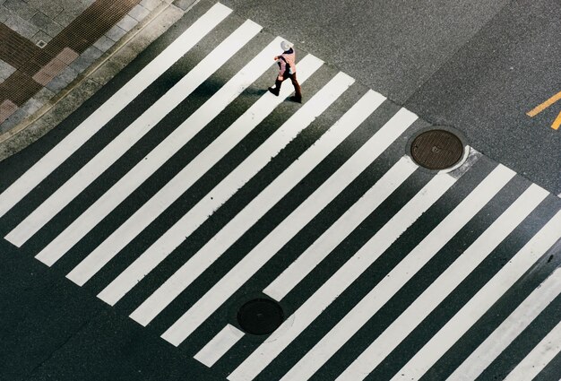 High angle view of woman walking on zebra crossing