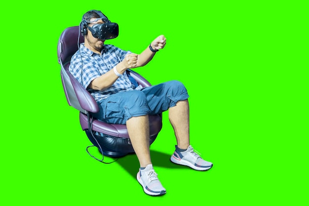 Photo high angle view of woman wearing virtual reality simulator while sitting on vehicle against green background
