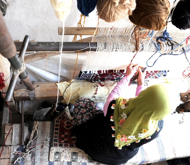 High angle view of woman weaving carpet