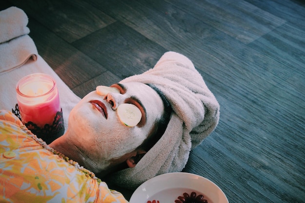 high angle view of woman with face mask lying at spa