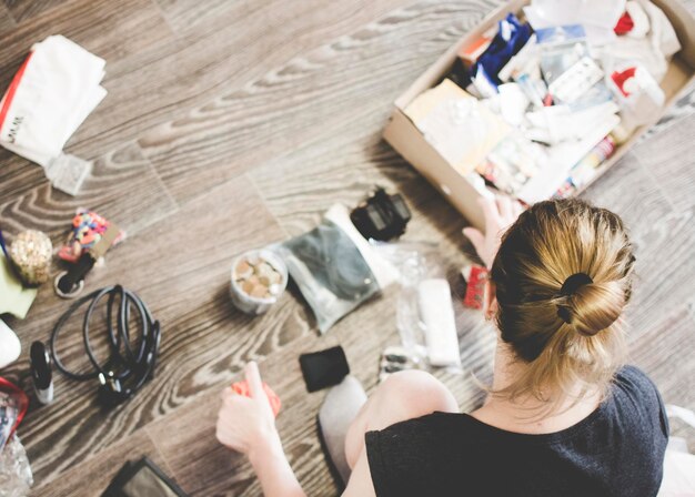 Photo high angle view of woman with various objects on floor