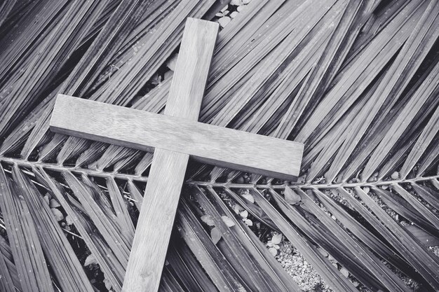 Photo high angle view of wooden cross on palm leaves