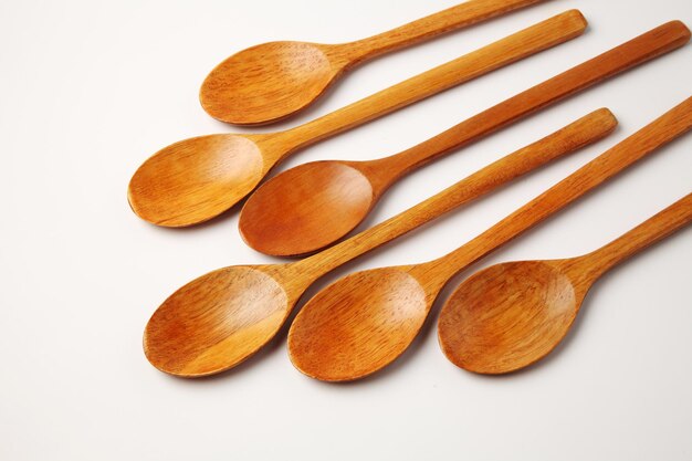 Photo high angle view of wooden spoons against white background