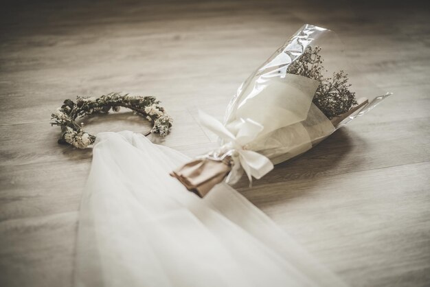 High angle view of wreath and bouquet with veil on hardwood floor