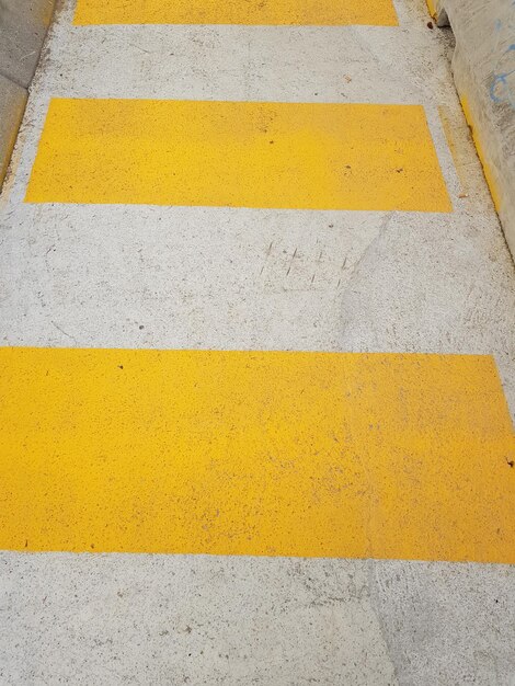 High angle view of yellow arrow symbol on road