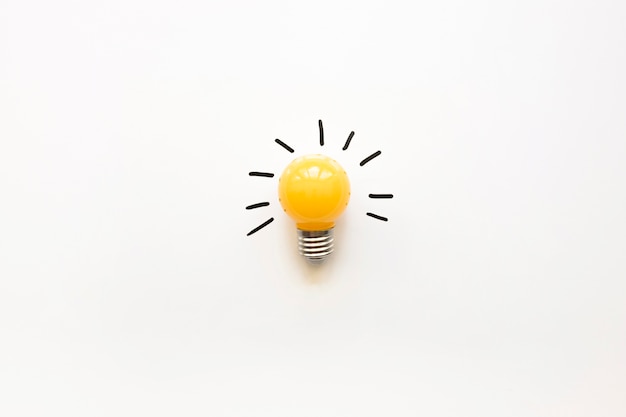 Photo high angle view of yellow electric bulb on white background