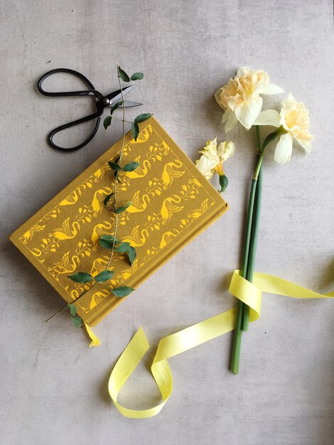 High angle view of yellow flowers and book on table