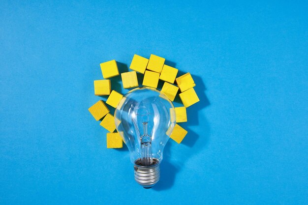 High angle view of yellow light bulb against blue background