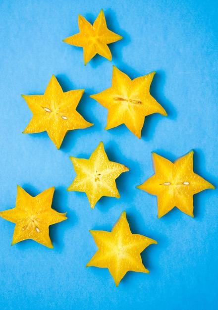 Foto vista ad alto angolo di fette di starfruit gialle su sfondo blu