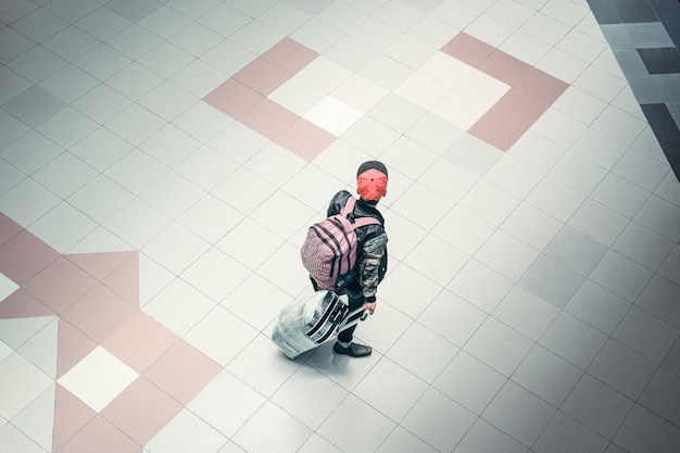 Photo high angle view of young man walking on tiled floor